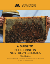 University of Minnesota Extension, A Guide to Beekeeping in Northern Climates, 3rd Edition, University of Minnesota, Department of Entomology, Bee Lab, Bee Squad, St. Paul, Minnesota, BeeLab.umn.edu. Image of An apiculturalist holding up a beehive. Wording is written in black within a golden background.